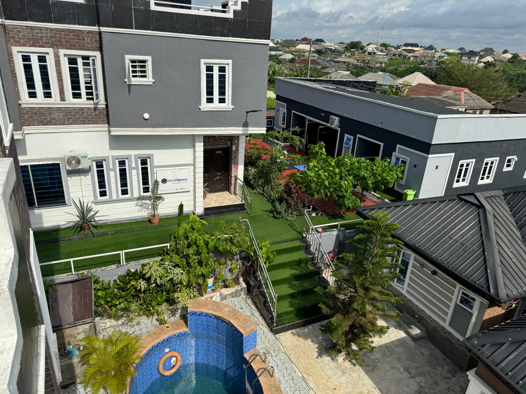 Aerial view of BlockSpace compound with swimming pool and landscaped gardens
