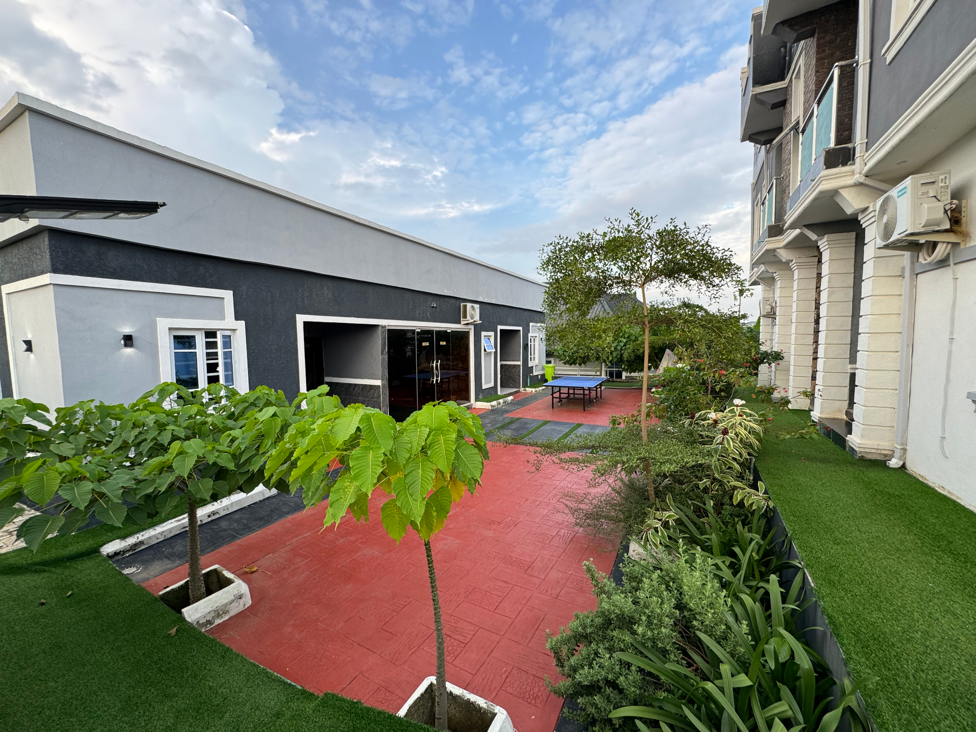 Outdoor facility area with red walkway and green spaces